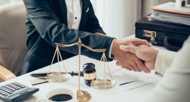 Businessman shaking hands to seal a deal with his partner lawyers or attorneys discussing a contract agreement