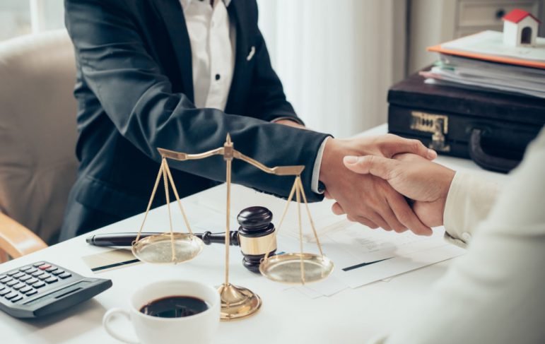 Businessman shaking hands to seal a deal with his partner lawyers or attorneys discussing a contract agreement