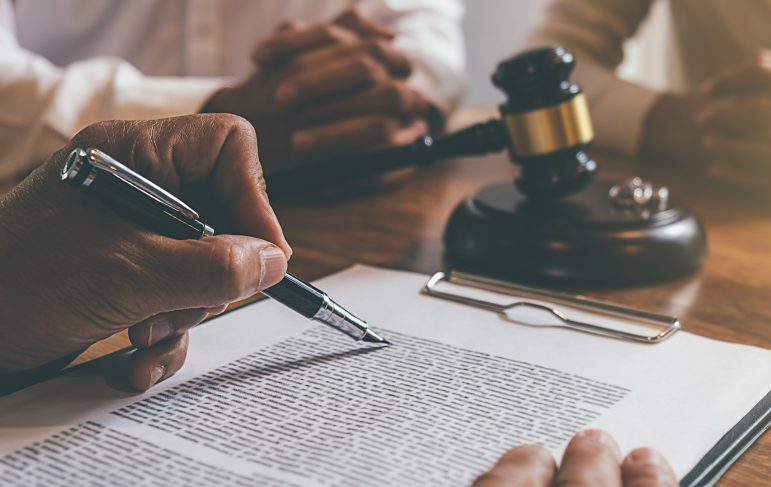 Judge gavel with Justice lawyers deciding, consultation on marriage divorce between married couple and signing divorce documents on table. Concepts of Law and Legal sevices.