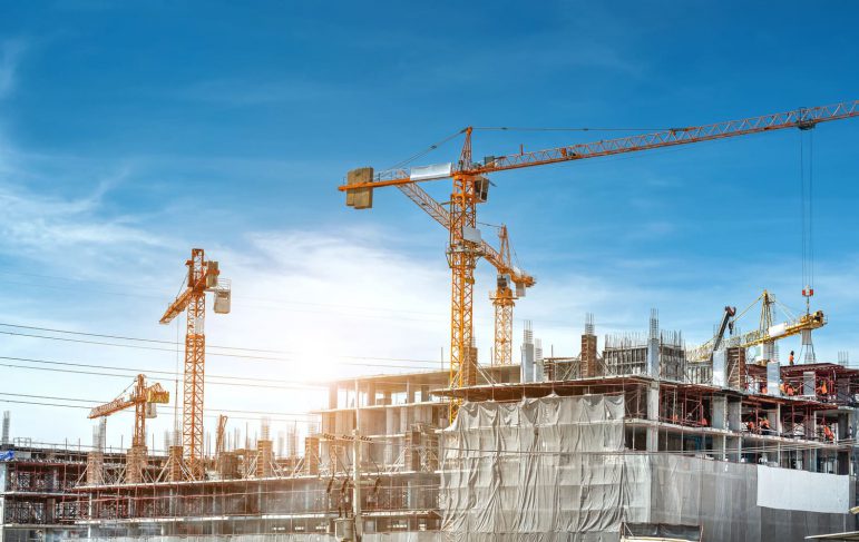 A bustling construction site featuring cranes and various construction equipment actively engaged in building activities.
