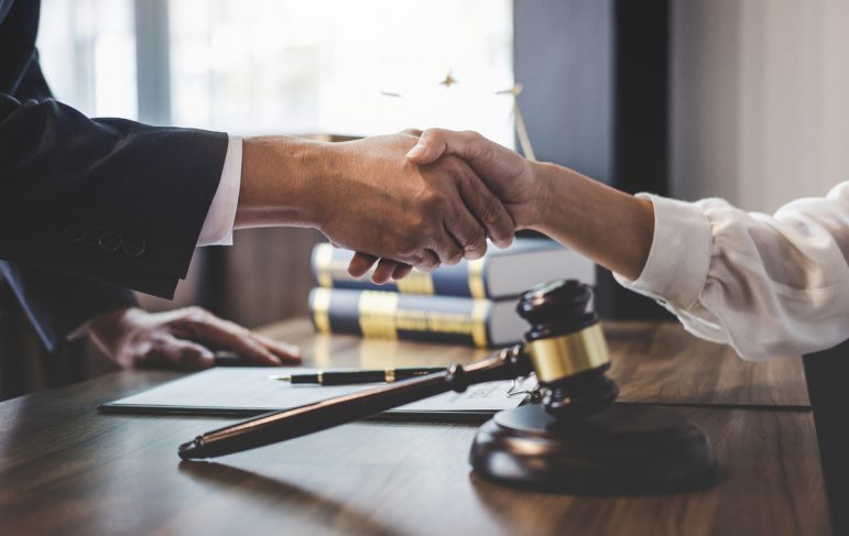 Good service cooperation of Consultation between a male lawyer and business woman customer, Handshake after good deal agreement, Law and Legal concept.